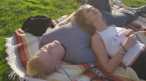 Cute girl and boy lay at the park Stock Footage 53557053