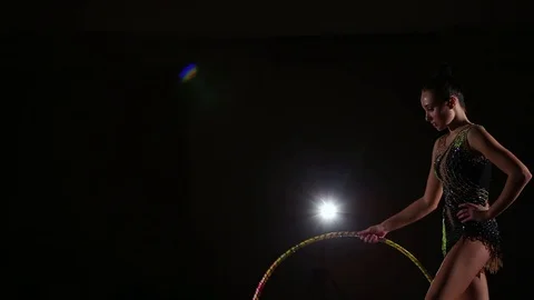 Cute girl athlete performs elements of rhythmic gymnastics with hoop in gym Stock Footage 104126476