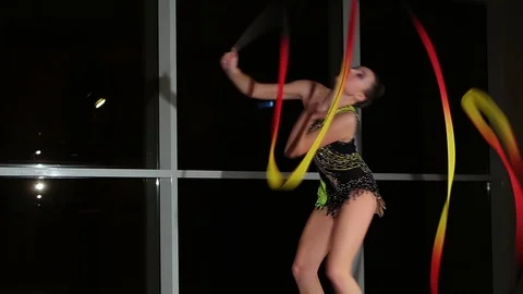 Cute girl athlete performs elements of rhythmic gymnastics with ribbon in gym Stock Footage 104126697