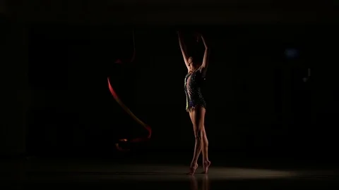 Cute girl athlete performs elements of rhythmic gymnastics with ribbon Stock Footage 104689704