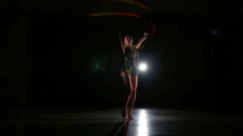 Cute girl athlete performs elements of rhythmic gymnastics with ribbon Stock Footage 104689803