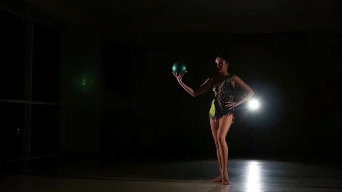 Cute girl athlete performs elements of rhythmic gymnastics with ball in gym Stock Footage 104689860