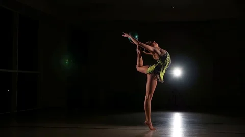 Cute girl athlete performs elements of rhythmic gymnastics with ball in gym Stock Footage 104689896