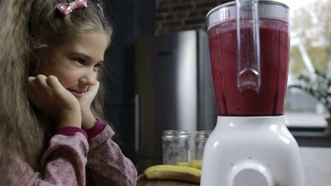 Cute girl blending fresh berry smoothie in blender Stock Footage