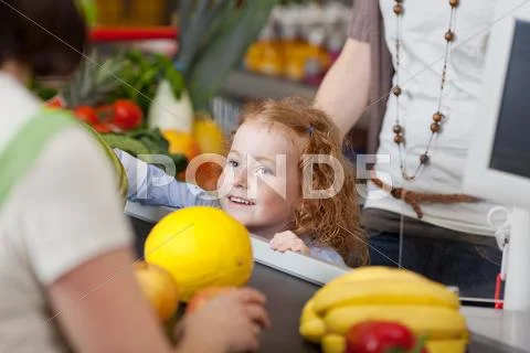 Cute girl at the checkout counter Stock Photos