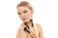 The cute girl with cosmetic brushes on the white background Photo