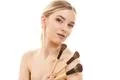 The cute girl with cosmetic brushes on the white background Photo