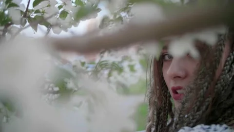 A cute girl with dreadlocks poses by a tree with leaves Stock Footage 154723080