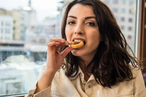 Cute girl eats deep fried onion ring Stock Photos