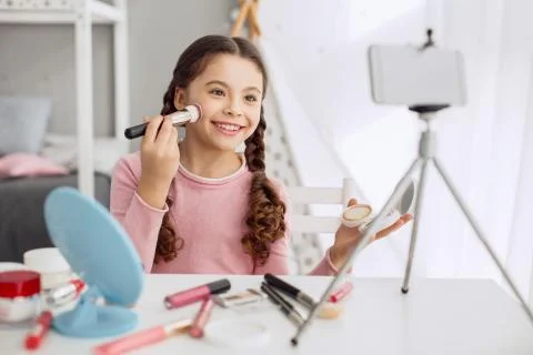 Cute girl filming makeup tutorial with her phone Stock Photos
