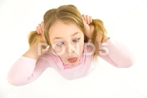 The cute girl grimace on the white background. View from above Stock Photos