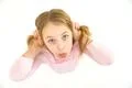 The cute girl grimace on the white background. View from above Photo
