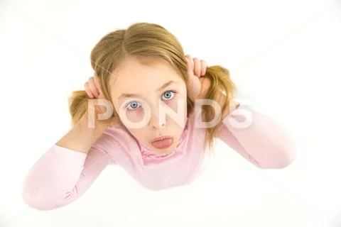 The cute girl grimace on the white background. View from above Stock Photos
