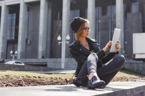 Cute girl hacker programmer uses a tablet computer outdoors Stock Photos