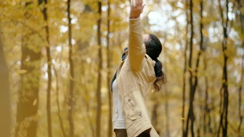 A cute girl has fun and enjoys the beauty of autumn leaves and spins in the park 스톡 동영상 218328433