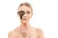 The cute girl holding a cosmetic brush on the white background Photo