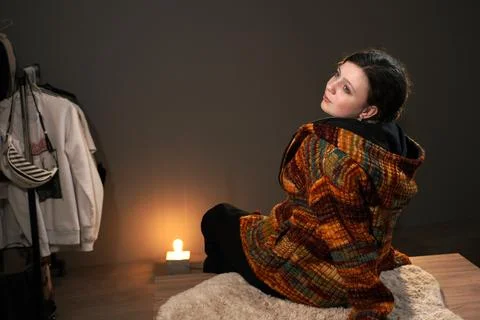 A cute girl in a knitted sweater of ocher autumn colors in a room. Stock Photos