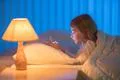 The cute girl lay on the bed and phone. Evening night time Photo