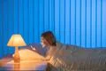 The cute girl lay on the bed and phone. Evening night time Photo