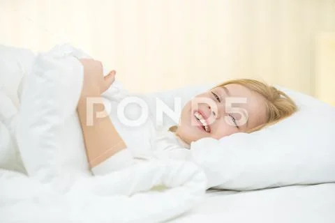 The cute girl lay on the bed Stock Photos