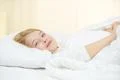 The cute girl lay on the bed with white linens Photo