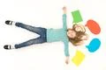 The cute girl lay on the floor near the dialog signs. View from above Photo