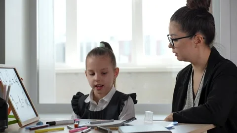A cute girl learning maths, studies with a private teacher in the office Stock Footage 273566918