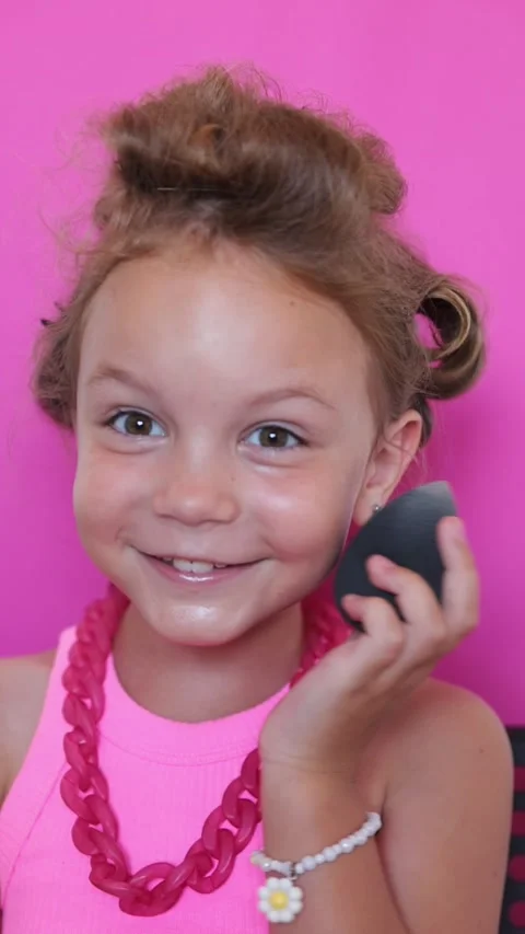 Cute girl make-up on camera, in pink clothes on pink background, little blogger Stock Footage 247416191