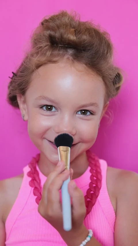 Cute girl make-up on camera, in pink clothes on pink background, little blogger Stock Footage 247416280