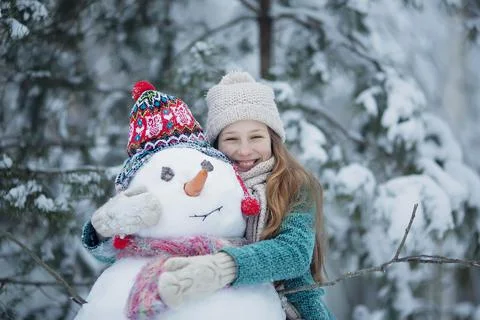 Cute girl is making a snowman. Stock Photos
