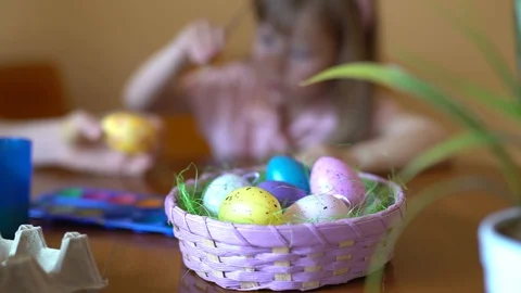 Cute girl paints an Easter egg. Mom helps her daughter to draw on the egg. Stock Footage 104991482
