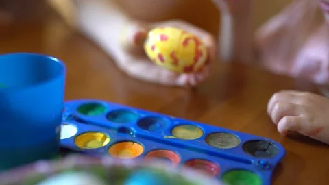 Cute Girl Paints An Easter Egg. Mom Helps Her Daughter To Draw On The Egg. Stock Footage 105095733
