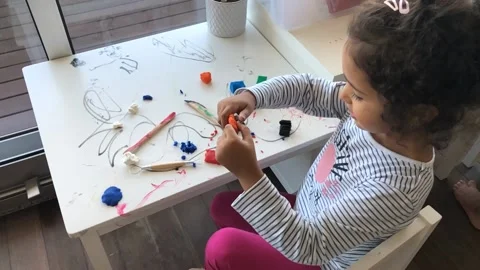Cute Girl Playing With Clay While Sitting At Home Stock Footage 172501630
