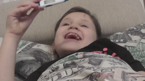 Cute Girl Pulls Out a Thermometer and Rejoices That There is no Temperature Stock Footage 72613991