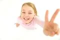 The cute girl show two fingers to the camera. View from above Photo