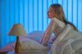 The cute girl sitting on the bed. Evening night time Photo