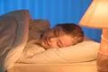 The cute girl sleeping on the bed. Evening night time Photo