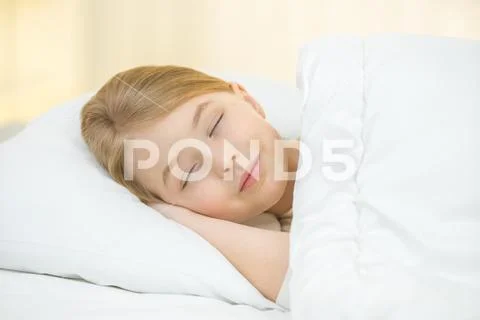 The cute girl sleeping on the bed Stock Photos