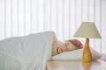 The cute girl sleeping on the bed with white linens Photo
