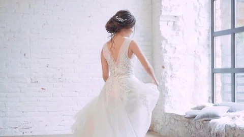 Cute girl with soft features, spinning in long elegant white dress near large Stock Footage 100287882