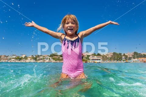 Cute girl standing in sea shallow like a star Stock Photos