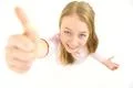 The cute girl thumbs up to the camera. View from above Photo