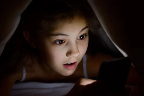 Cute girl using modern device for sending messages or playing games Stock Photos