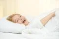 The cute girl yawn and lay on the bed Photo