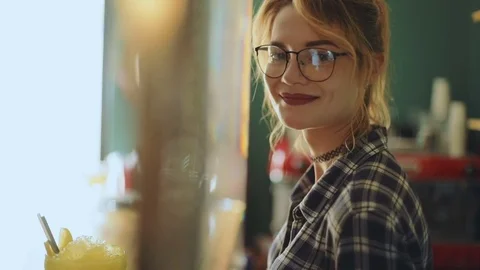 Cute girl young woman female standing bar cafe summer sunny day inside side view Stock Footage
