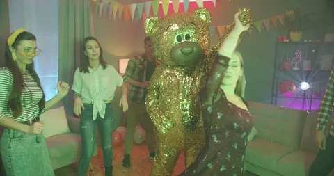 Cute golden life-size puppet of teddy bear dancing with a beautiful young blonde Stock Footage 122512866