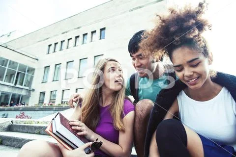 Cute group of teenages at the building of university with books huggings Stock Photos