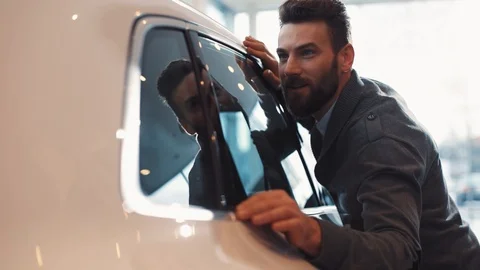 Cute guy with beard going to buy prestigious car in popular car dealership of Stock Footage 86174924