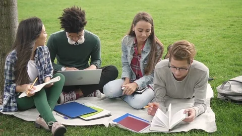 Cute guy in black glasses is reading book and compare information with other Video stock 101794550