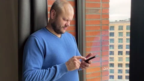 A cute guy scrolling a smartphone Stock Footage 221923229